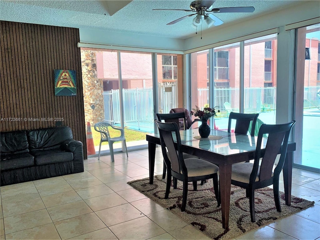 dining area with a textured ceiling, ceiling fan, and light tile patterned flooring