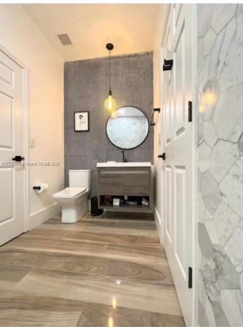 bathroom featuring hardwood / wood-style floors, vanity, and toilet