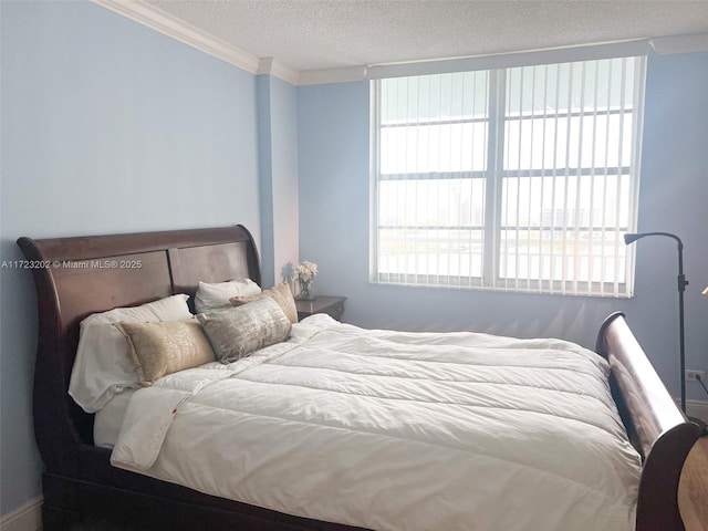 bedroom with multiple windows, crown molding, and a textured ceiling