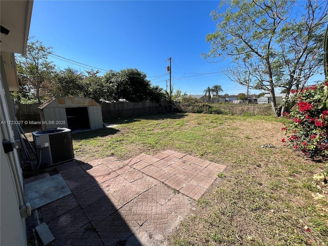 view of yard with a patio, central AC, and a storage shed