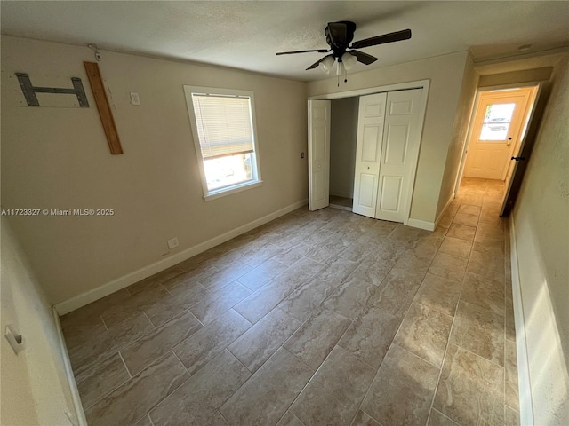 unfurnished bedroom featuring multiple windows, ceiling fan, and a closet