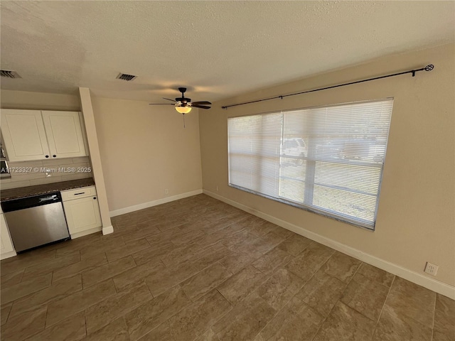 interior space with white cabinetry, ceiling fan, dishwasher, backsplash, and a textured ceiling