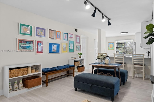 interior space with light hardwood / wood-style flooring and rail lighting