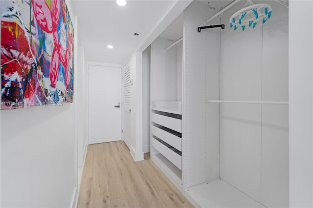 walk in closet with light wood-type flooring