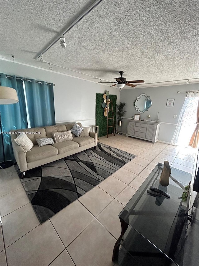 tiled living room with ceiling fan, track lighting, and a textured ceiling