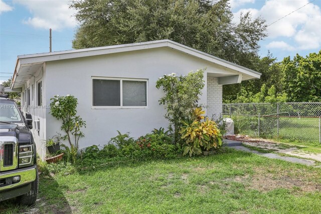 property entrance with a lawn and a patio