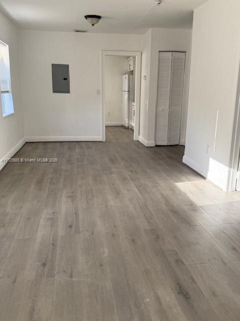 1545 NW 68st, Miami, FL 33147 - empty room featuring electric panel, wood finished floors, and baseboards