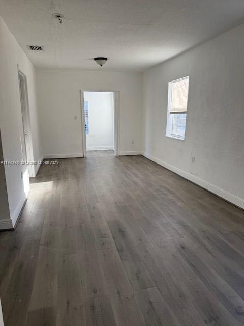 1545 NW 68st, Miami, FL 33147 - unfurnished room with dark wood-style floors, visible vents, and baseboards