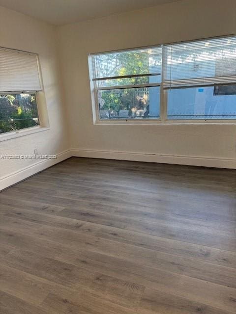 1545 NW 68st, Miami, FL 33147 - unfurnished room featuring wood finished floors, a healthy amount of sunlight, and baseboards