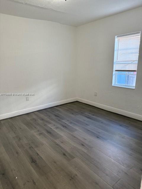 1545 NW 68st, Miami, FL 33147 - unfurnished room featuring baseboards and dark wood finished floors