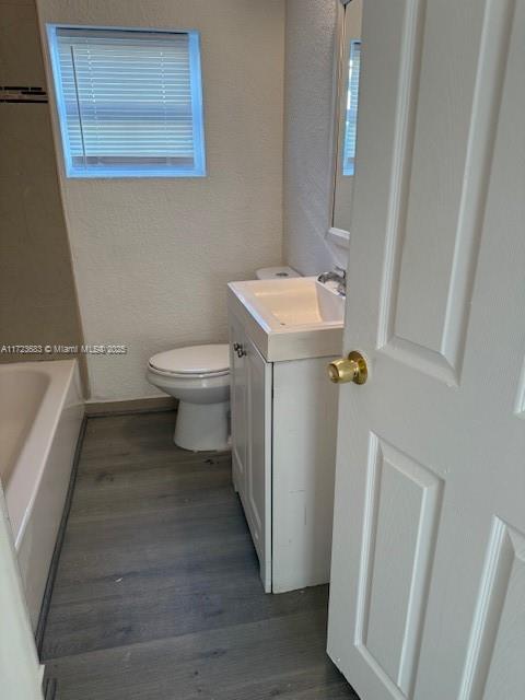 1545 NW 68st, Miami, FL 33147 - full bath with a wealth of natural light, toilet, a tub, wood finished floors, and vanity