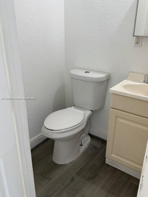 1545 NW 68st, Miami, FL 33147 - bathroom with baseboards, toilet, wood finished floors, a textured wall, and vanity