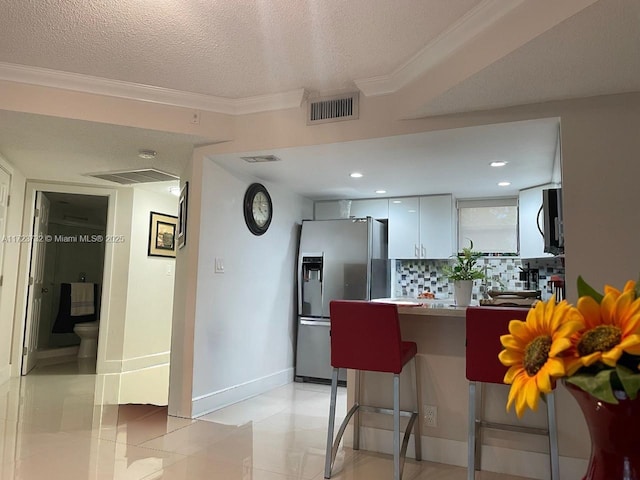 8290 Lake Dr Unit 235, Doral, FL 33166 - kitchen with stainless steel appliances, tasteful backsplash, a kitchen breakfast bar, a peninsula, and crown molding