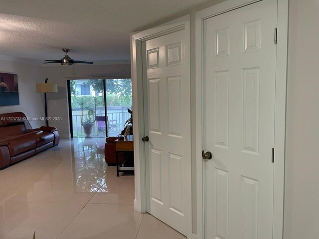 8290 Lake Dr Unit 235, Doral, FL 33166 - hallway with light tile patterned flooring, a textured ceiling, and baseboards