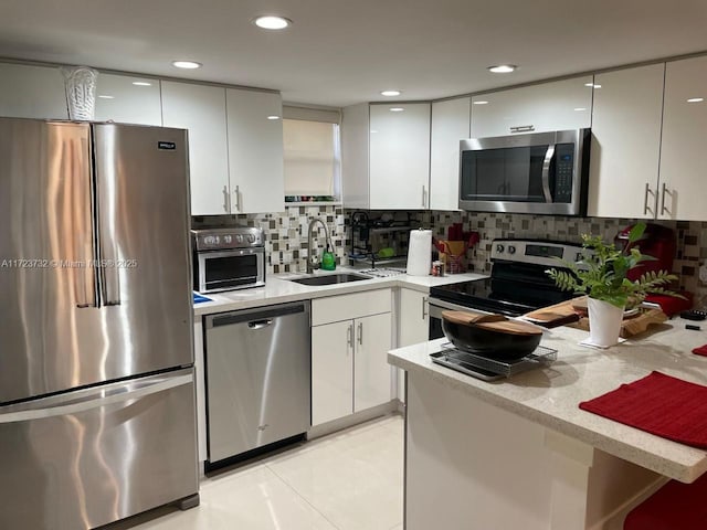 8290 Lake Dr Unit 235, Doral, FL 33166 - kitchen featuring stainless steel appliances, a sink, white cabinets, backsplash, and recessed lighting