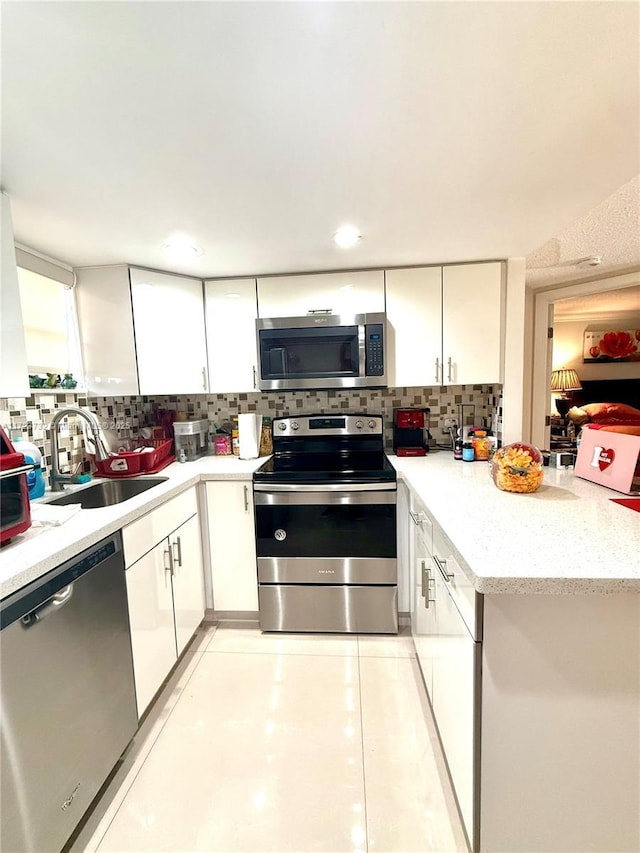 8290 Lake Dr Unit 235, Doral, FL 33166 - kitchen with appliances with stainless steel finishes, a sink, white cabinetry, and tasteful backsplash