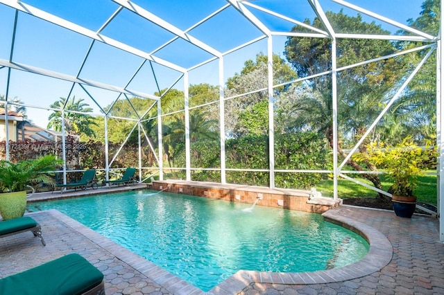 view of swimming pool featuring a lanai, a patio area, and pool water feature