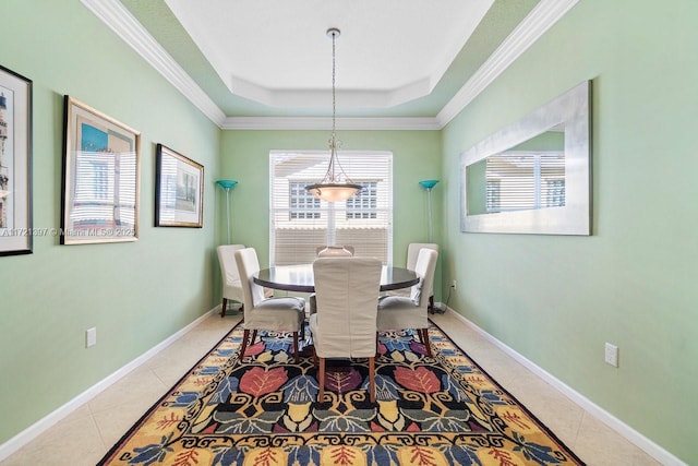 tiled dining area with a raised ceiling and ornamental molding