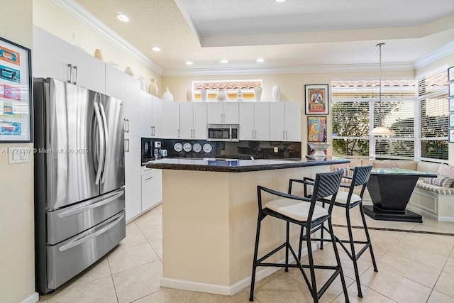 kitchen featuring stainless steel appliances, a center island, white cabinetry, a breakfast bar area, and light tile patterned flooring