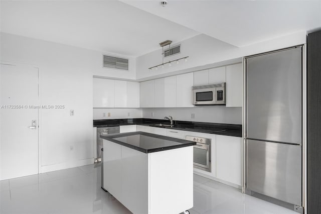 kitchen with sink, white cabinetry, appliances with stainless steel finishes, and a center island