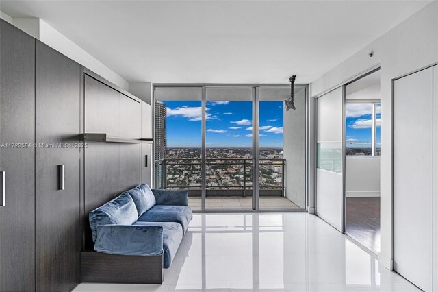 living area featuring tile patterned flooring, floor to ceiling windows, and a healthy amount of sunlight