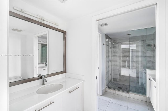 bathroom with vanity, tile patterned flooring, and a shower with door