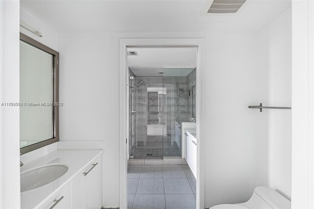 bathroom featuring toilet, vanity, tile patterned flooring, and walk in shower