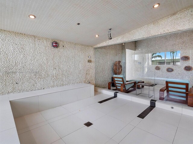 misc room featuring vaulted ceiling and tile patterned floors