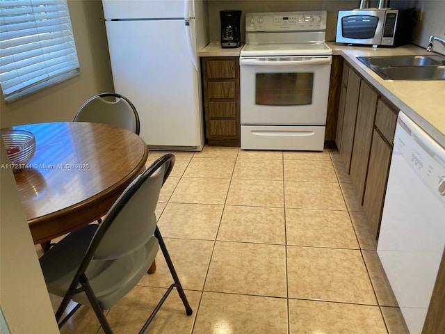 kitchen with sink, white appliances, and light tile patterned flooring