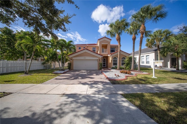 mediterranean / spanish-style house featuring a garage and a front yard