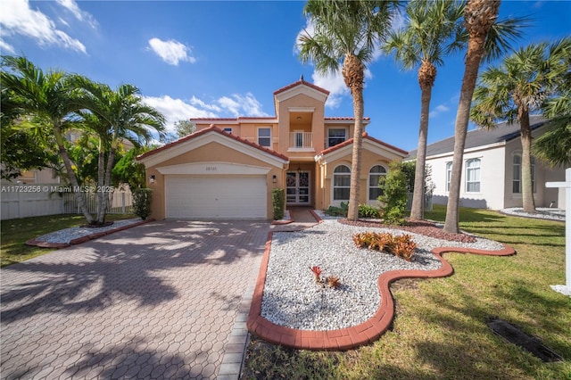 mediterranean / spanish-style house featuring a garage and a front lawn