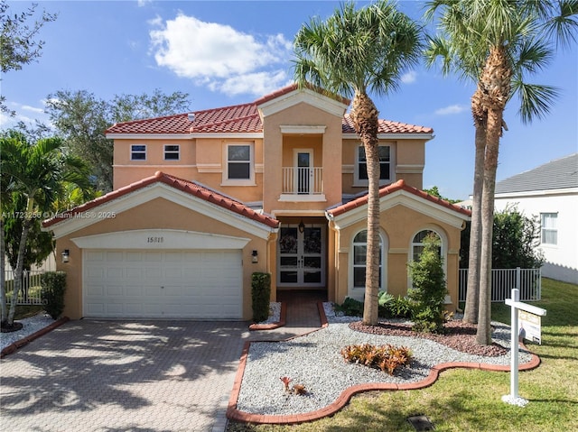 mediterranean / spanish house with a balcony and french doors