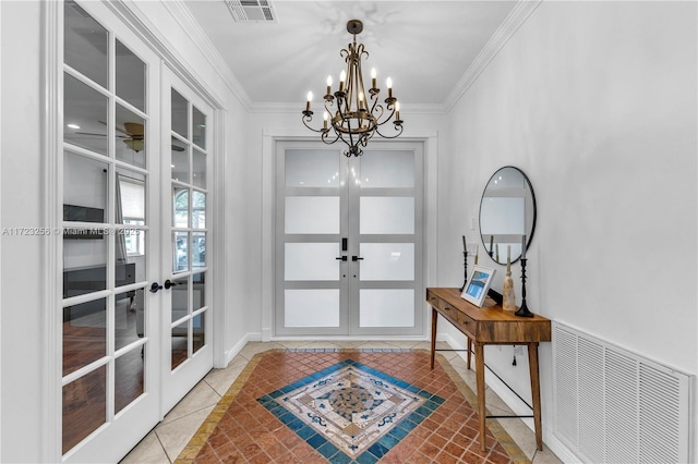 tiled foyer featuring french doors, a chandelier, and ornamental molding