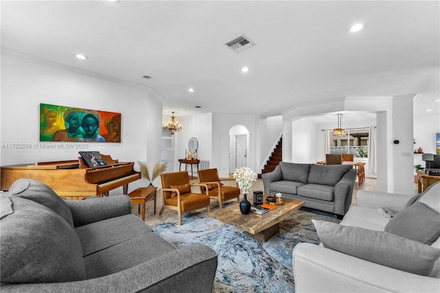 living room with crown molding and an inviting chandelier