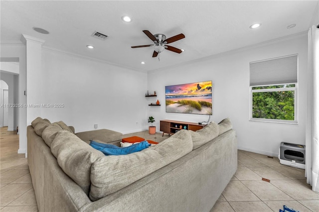 living room with ceiling fan, light tile patterned floors, ornamental molding, and heating unit