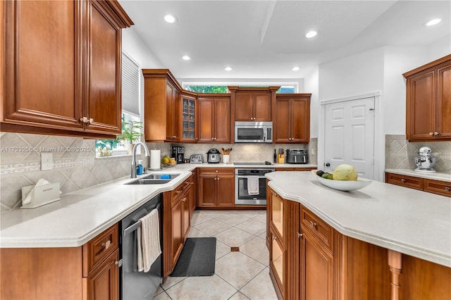 kitchen featuring light tile patterned floors, sink, appliances with stainless steel finishes, and tasteful backsplash