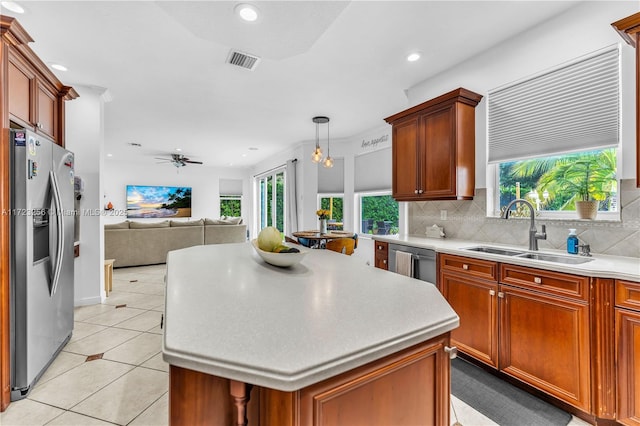 kitchen featuring ceiling fan, sink, a center island, pendant lighting, and appliances with stainless steel finishes