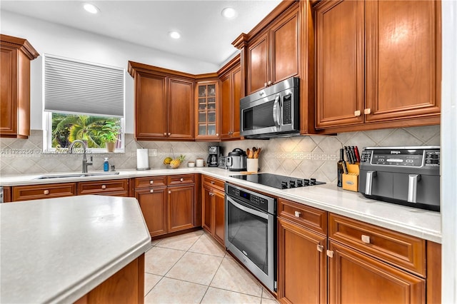 kitchen featuring light tile patterned floors, sink, appliances with stainless steel finishes, and tasteful backsplash