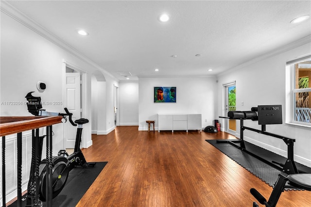 workout room with dark hardwood / wood-style floors and crown molding