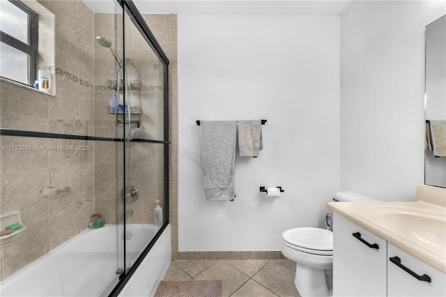 full bathroom featuring shower / bath combination with glass door, tile patterned flooring, vanity, and toilet