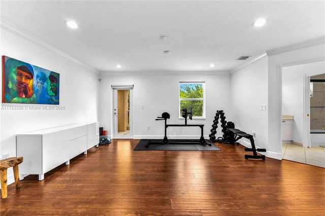 workout area featuring wood-type flooring and ornamental molding