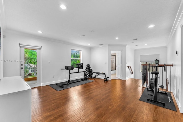 workout area with hardwood / wood-style flooring and ornamental molding