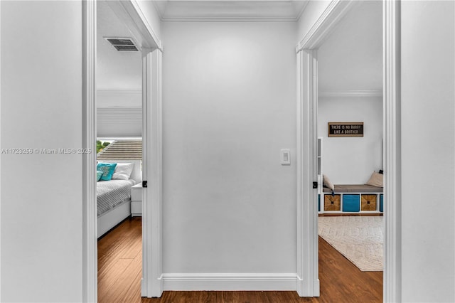 hall with dark wood-type flooring and ornamental molding