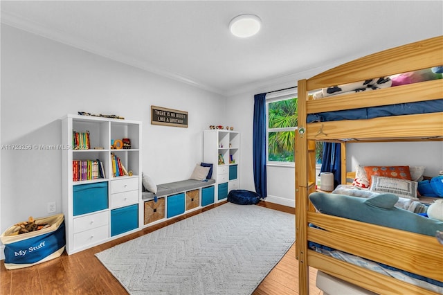 bedroom with hardwood / wood-style floors and crown molding