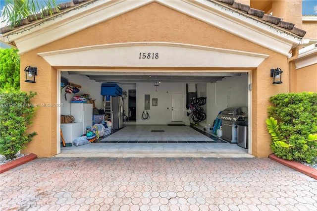 garage featuring electric panel and stainless steel fridge