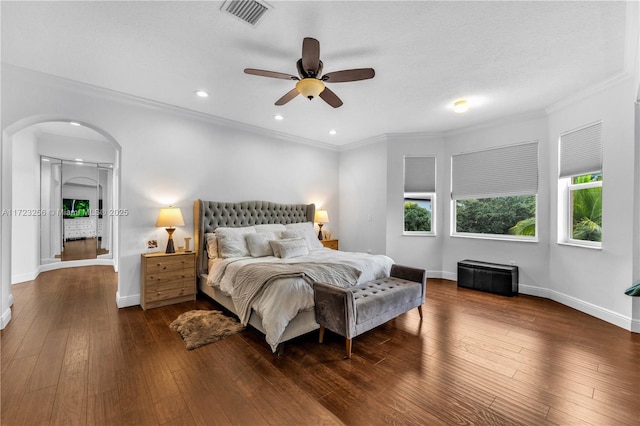 bedroom featuring dark hardwood / wood-style floors, ceiling fan, and ornamental molding