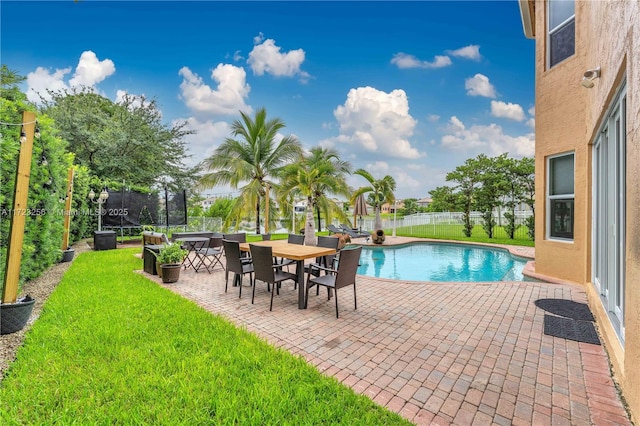 view of pool with a trampoline, a patio area, and a lawn