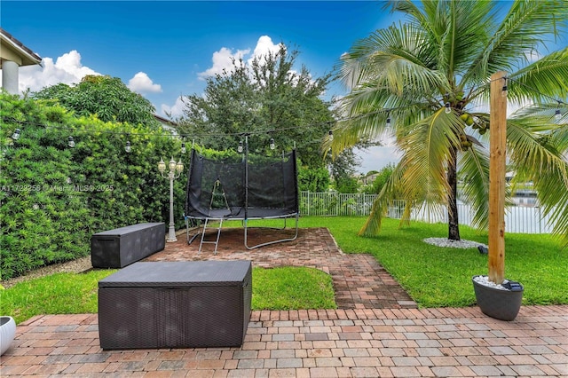 view of patio with a trampoline and a water view