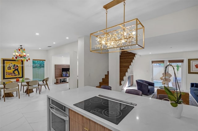 kitchen featuring pendant lighting, black electric cooktop, and stainless steel oven