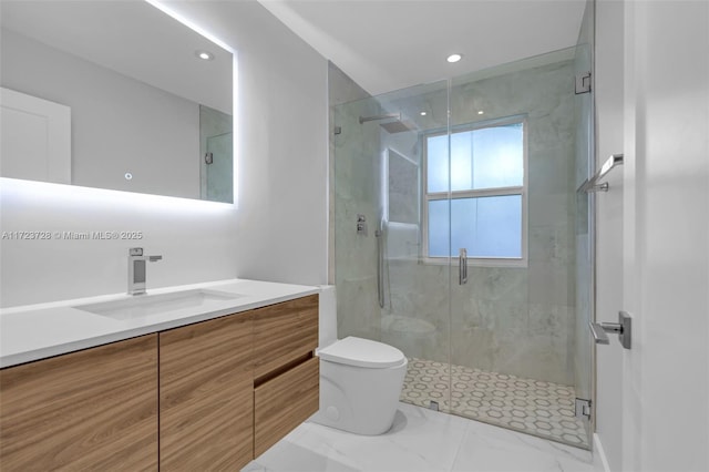 bathroom featuring a shower with door, vanity, and toilet